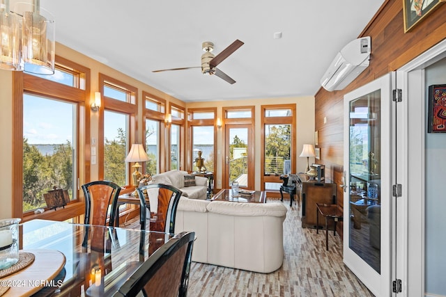 living room with ceiling fan, an AC wall unit, wooden walls, and light hardwood / wood-style flooring