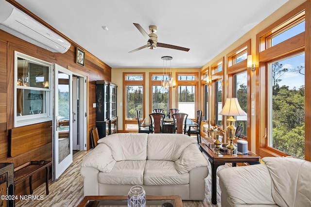 sunroom / solarium with ceiling fan with notable chandelier and a wealth of natural light