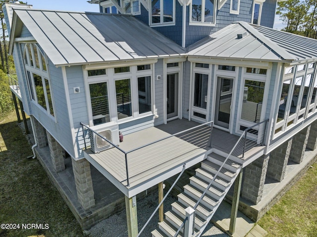 rear view of property featuring a wooden deck and a sunroom