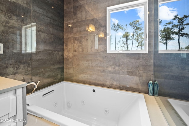 bathroom featuring tiled tub and vanity