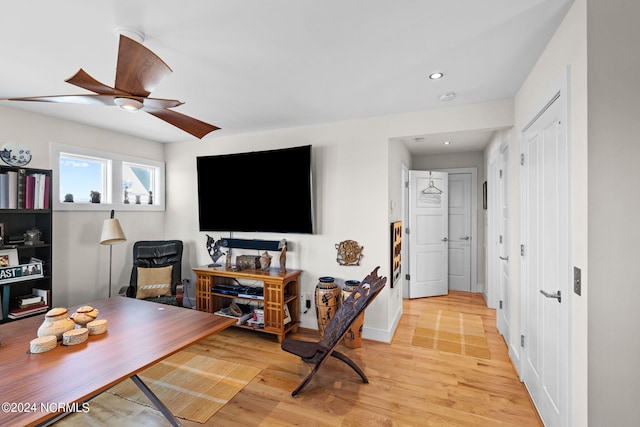 living room featuring light hardwood / wood-style flooring and ceiling fan