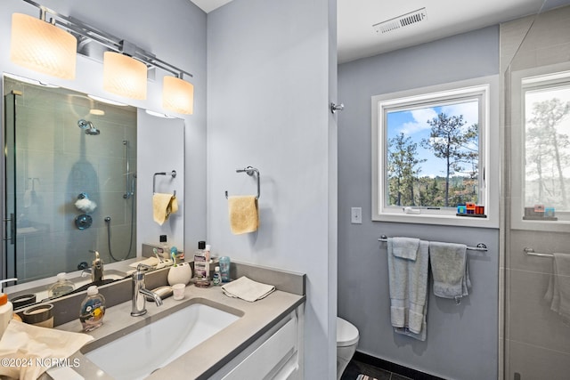 bathroom with walk in shower, vanity, toilet, and plenty of natural light