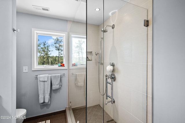 bathroom with tile patterned flooring, toilet, and walk in shower