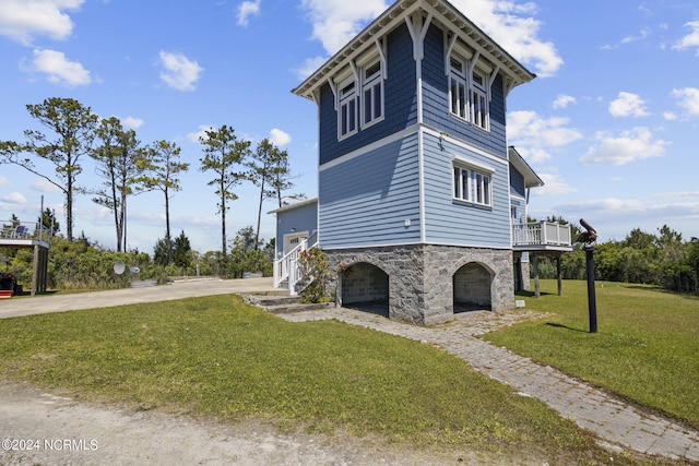 view of home's exterior with a lawn, a wooden deck, and a garage