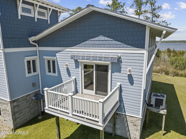 back of house with a lawn, central air condition unit, and a deck with water view