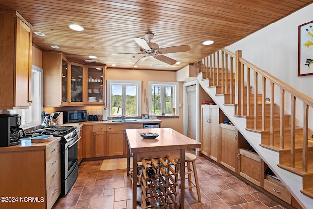 kitchen featuring gas stove, ceiling fan, sink, and wood ceiling