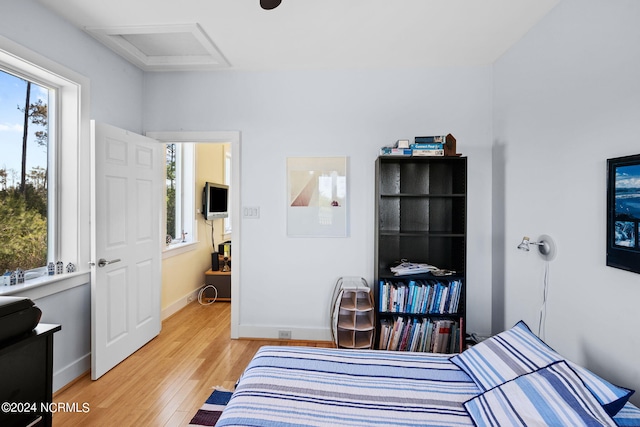 bedroom with hardwood / wood-style flooring and multiple windows