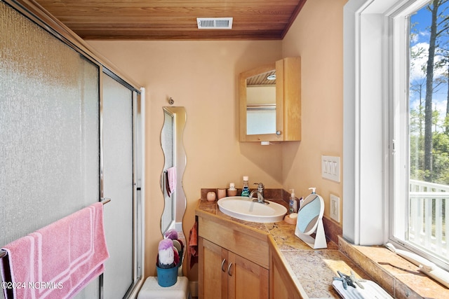 bathroom with vanity, a shower with door, and wood ceiling