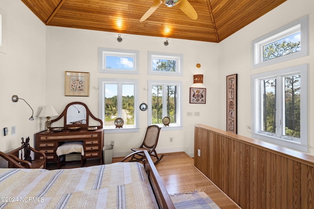 bedroom with ceiling fan, wooden ceiling, and multiple windows