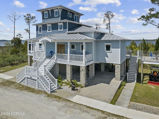 raised beach house featuring a porch and a carport