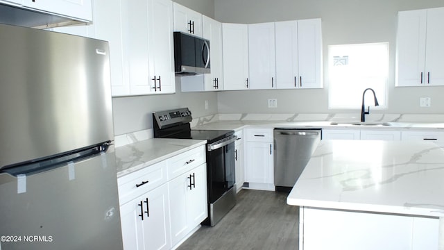 kitchen with appliances with stainless steel finishes, white cabinets, and a sink