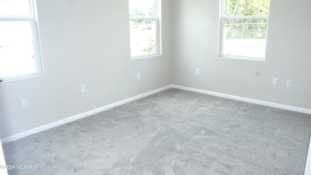 unfurnished room with carpet floors and baseboards