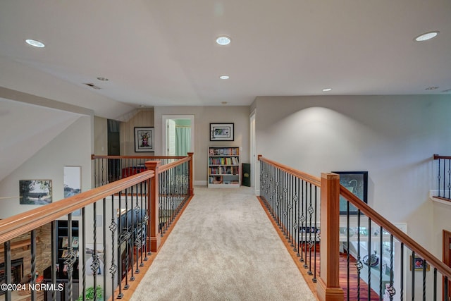 hall featuring light carpet and vaulted ceiling