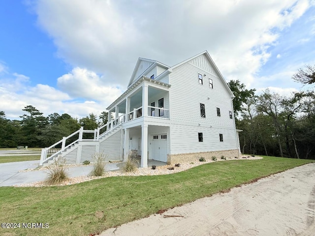 view of property exterior featuring covered porch, a garage, and a yard