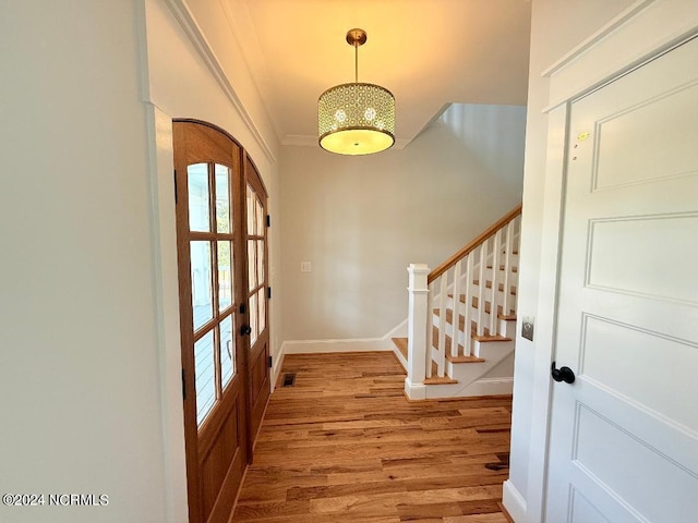 entrance foyer featuring french doors, ornamental molding, and hardwood / wood-style flooring