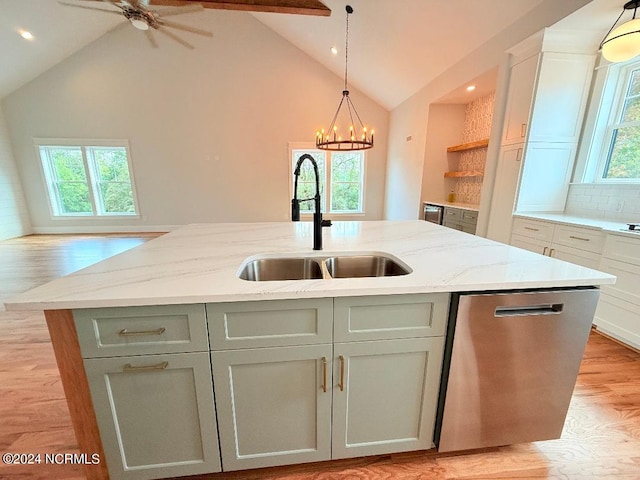 kitchen featuring dishwasher, a healthy amount of sunlight, sink, and an island with sink