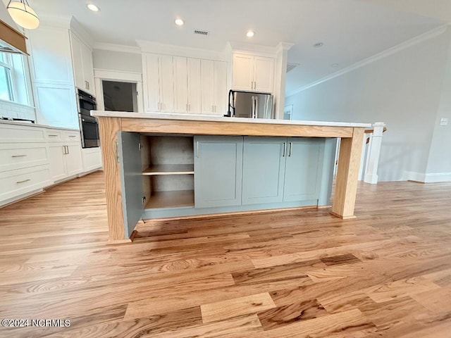 kitchen featuring white cabinetry, stainless steel fridge, light hardwood / wood-style floors, and a kitchen island with sink