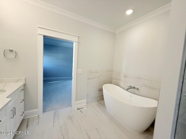 bathroom with vanity, a tub to relax in, crown molding, and tile walls