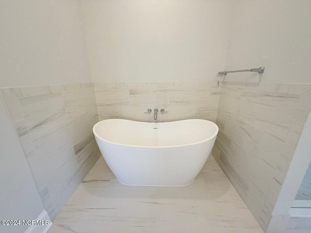 bathroom with a bathtub and tile walls