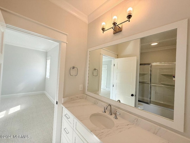 bathroom with vanity, combined bath / shower with glass door, and crown molding