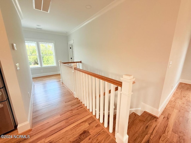 stairway with hardwood / wood-style flooring and ornamental molding