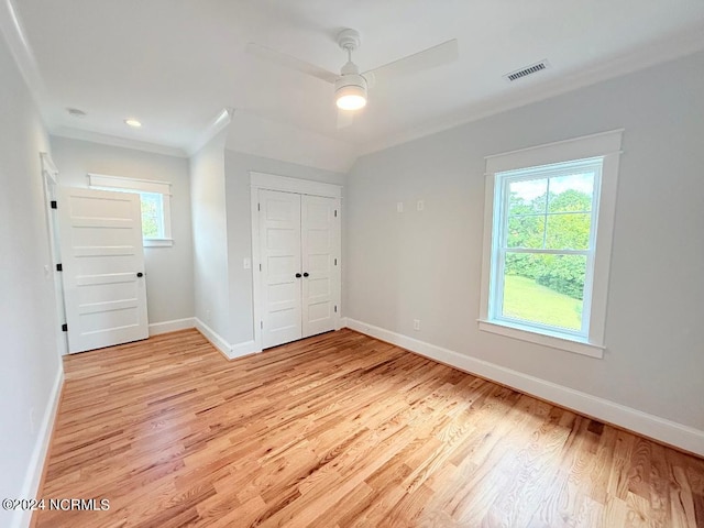 unfurnished bedroom with multiple windows, ceiling fan, a closet, and light wood-type flooring