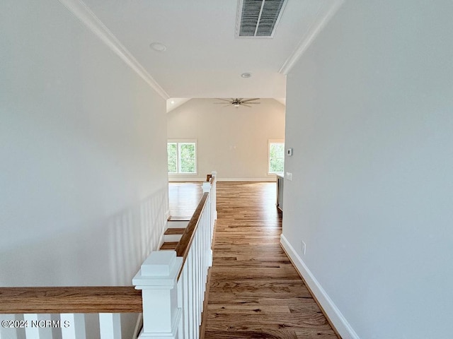 hall featuring vaulted ceiling, light hardwood / wood-style flooring, and crown molding