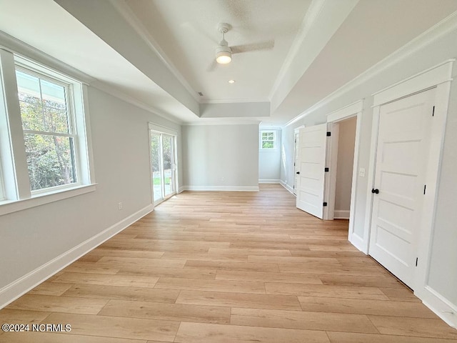 empty room with ceiling fan, light hardwood / wood-style flooring, and crown molding