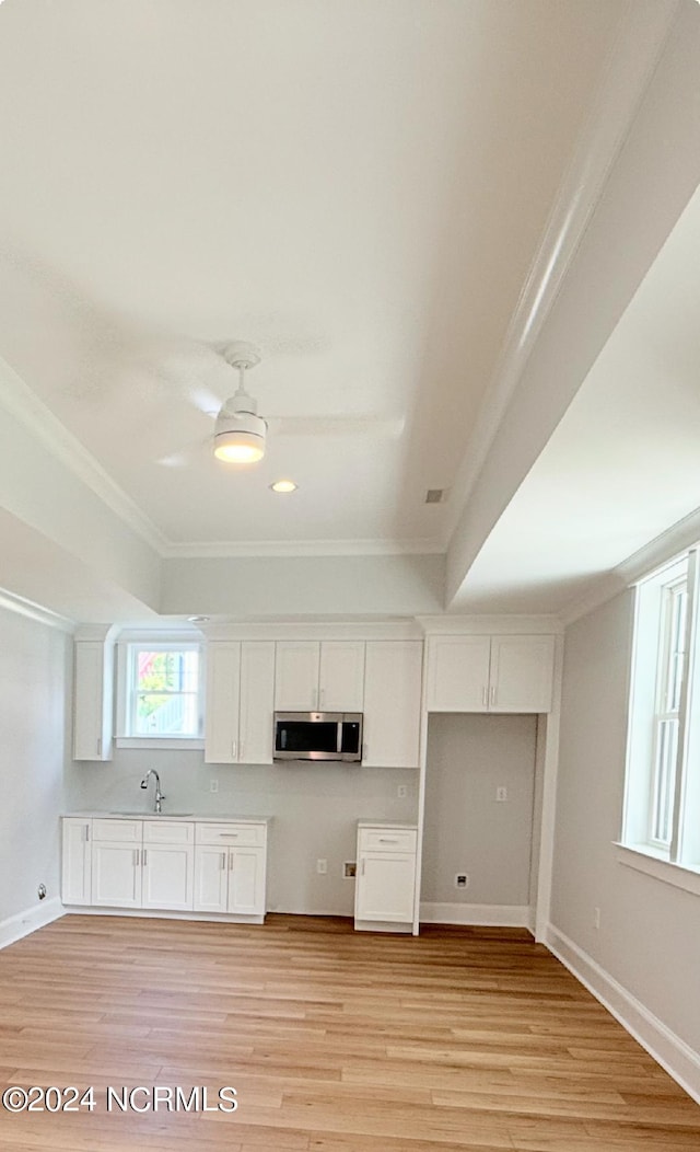 kitchen featuring ceiling fan, crown molding, sink, light hardwood / wood-style flooring, and white cabinetry