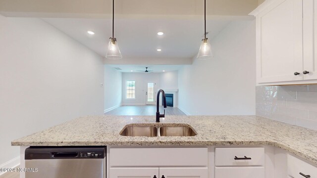 kitchen featuring tasteful backsplash, white cabinetry, a sink, and stainless steel dishwasher