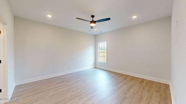 empty room with a ceiling fan, baseboards, and wood finished floors