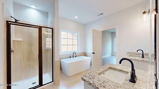 full bath featuring recessed lighting, visible vents, vanity, a soaking tub, and a stall shower