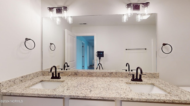 full bath featuring double vanity, visible vents, and a sink