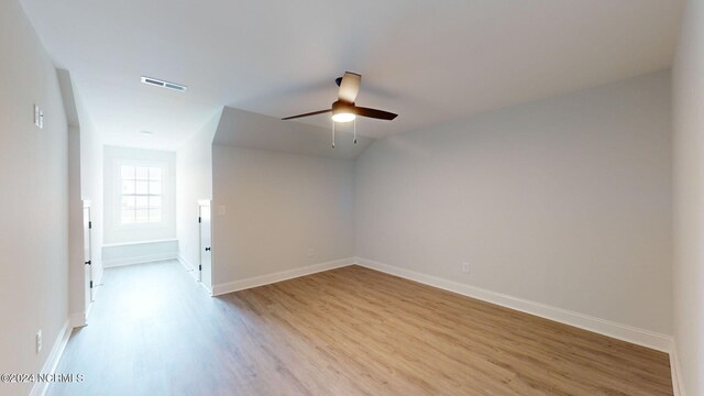 unfurnished room with light wood-style floors, visible vents, ceiling fan, and baseboards