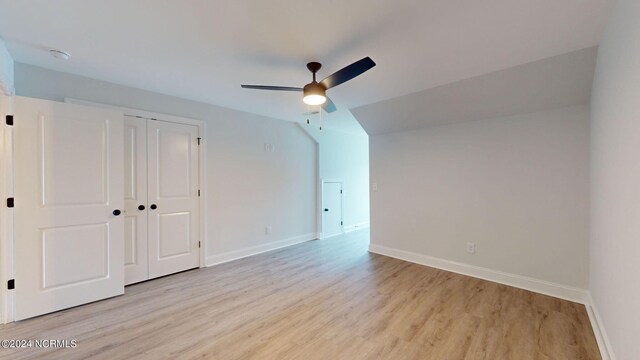 empty room featuring ceiling fan, light wood-type flooring, and baseboards