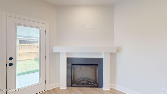 interior details featuring a fireplace, baseboards, and wood finished floors