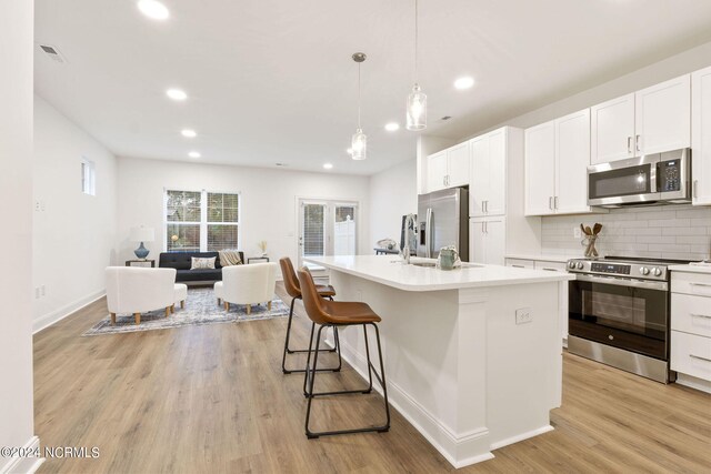 383 James St, Vass, NC 28394 - kitchen featuring a sink, tasteful backsplash, open floor plan, stainless steel appliances, and light wood-style floors