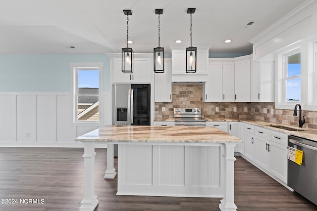 kitchen featuring appliances with stainless steel finishes, a kitchen island, sink, and white cabinets