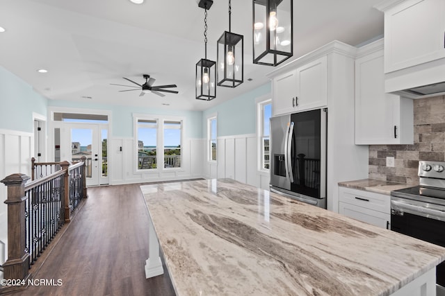 kitchen featuring white cabinets, decorative light fixtures, stainless steel appliances, dark hardwood / wood-style floors, and light stone countertops