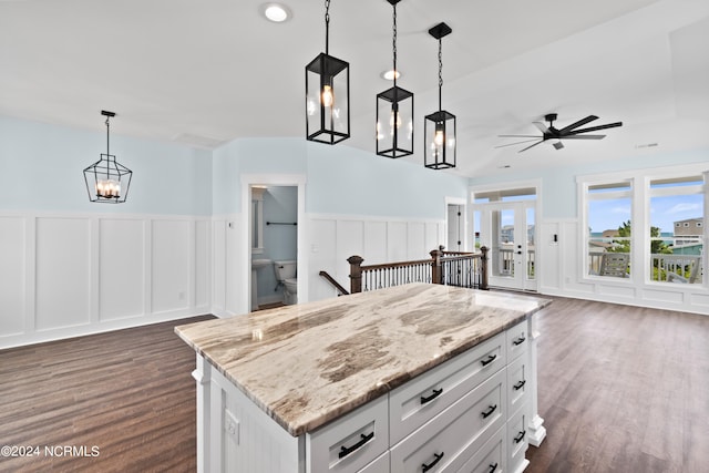 kitchen with dark hardwood / wood-style floors, white cabinets, decorative light fixtures, and a center island