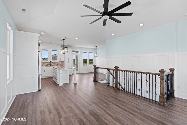 interior space with dark wood-type flooring, ceiling fan with notable chandelier, and sink