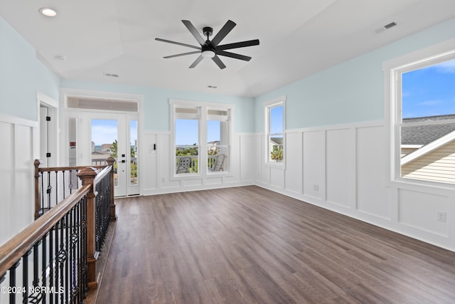 empty room with ceiling fan, dark hardwood / wood-style floors, and a wealth of natural light