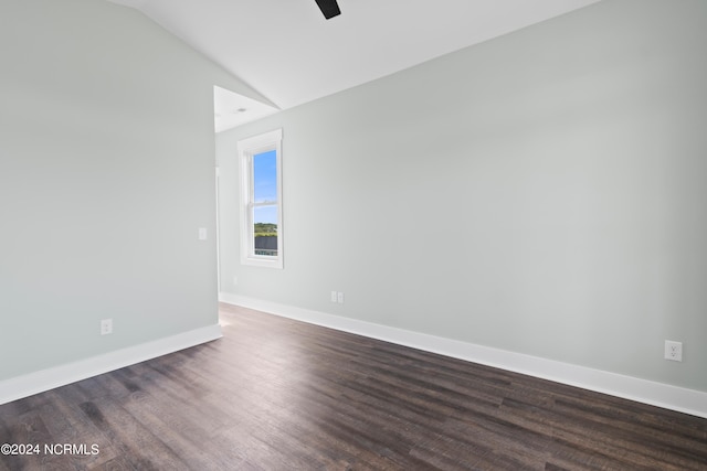 unfurnished room featuring lofted ceiling and dark wood-type flooring