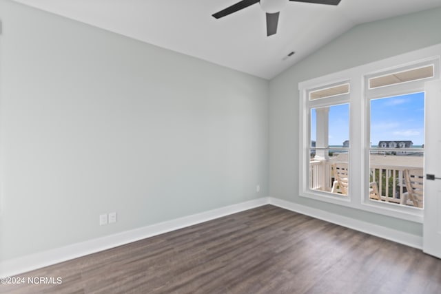 spare room with dark hardwood / wood-style floors, vaulted ceiling, and ceiling fan