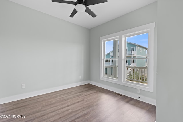 empty room with dark hardwood / wood-style floors and ceiling fan