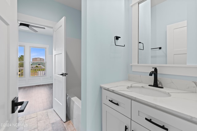 bathroom featuring a bathing tub, ceiling fan, vanity, and wood-type flooring