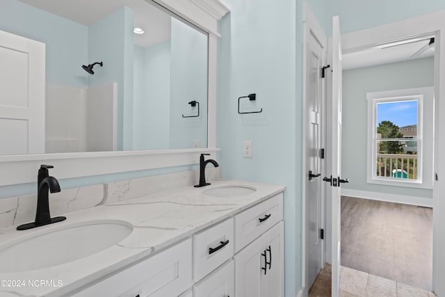 bathroom featuring wood-type flooring, vanity, and walk in shower