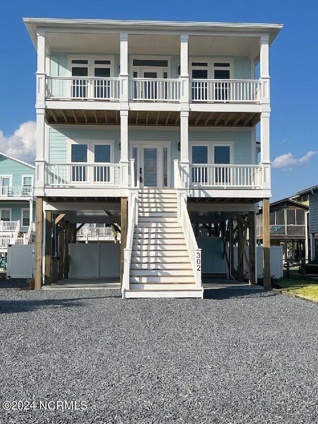 raised beach house with a carport and a balcony