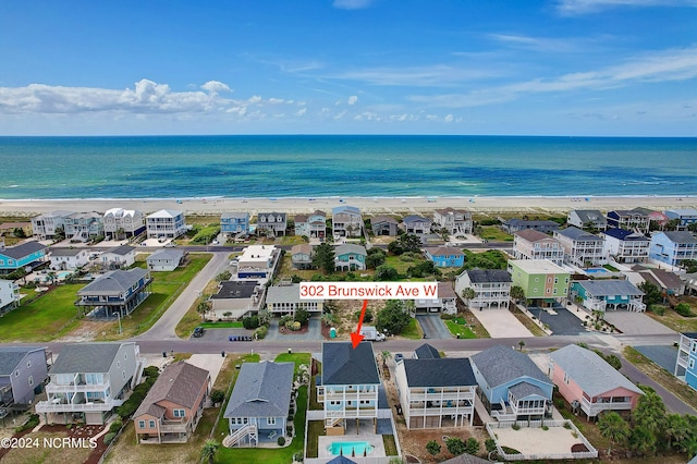 birds eye view of property with a water view and a beach view