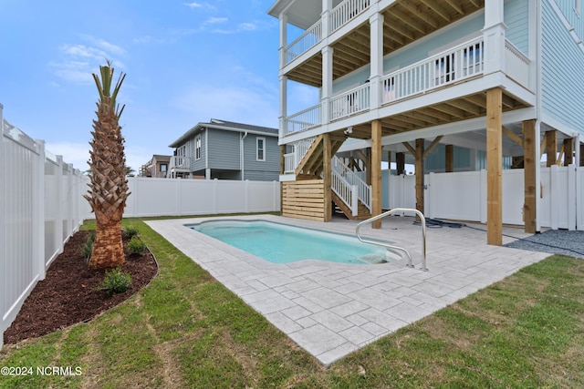 view of pool with a patio and a yard